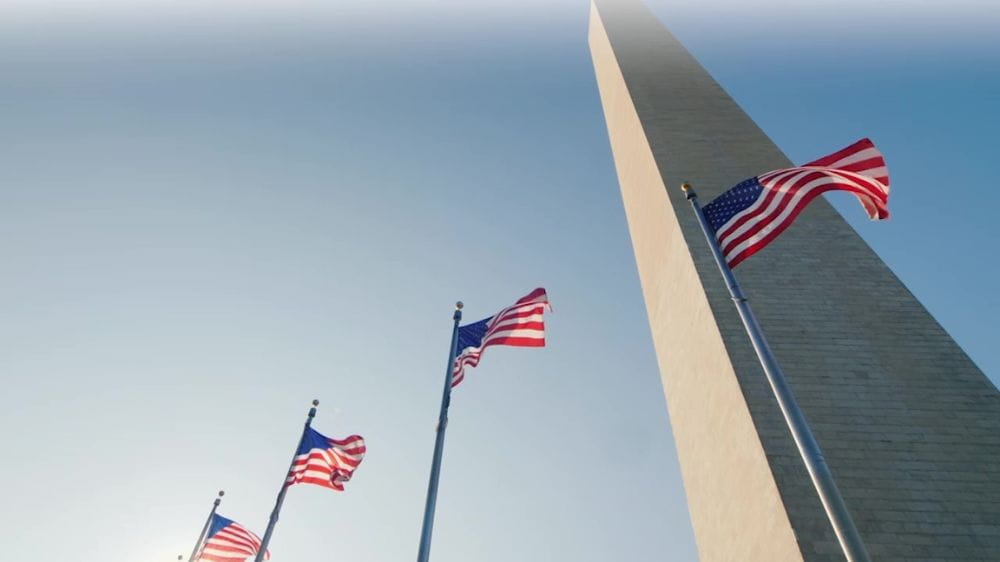 American flags waving beside the Washington Monument